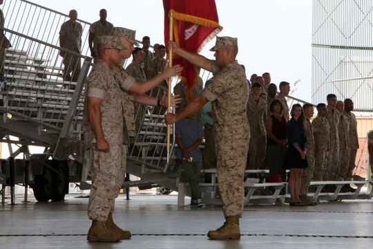 Sgt. Maj. Scott D. Grade, right, passes the 2nd Marine Aircraft Wing colors from Maj. Gen. Robert F. Hedelund, left, to Brig. Gen. Paul J. Rock Jr., center, during a change of command ceremony at Marine Corps Air Station Cherry Point, N.C., June 18, 2015. Hedelund relinquished his post as 2nd MAW commanding general to Rock during the ceremony. Grade is the sergeant major of Marine Air Control Group 28.