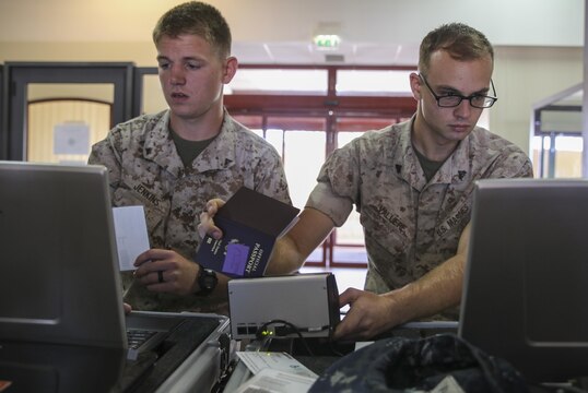 U.S. Marines Lance Cpl. Patrick Jenkins, left, a water support technician, and Cpl. Steven Valliere, a watch chief, process Marines through a non-combatant evacuation operation tracking system during evacuation control center sustainment training aboard Naval Air Station Sigonella, Italy, May 27, 2015. Approximately 30 Marines, all assigned to Special-Purpose Marine Air-Ground Task Force Crisis Response-Africa, participated in the training to refresh their evacuation operation skills. (U.S. Marine Corps photo by Cpl. Lucas Hopkins/Released)
