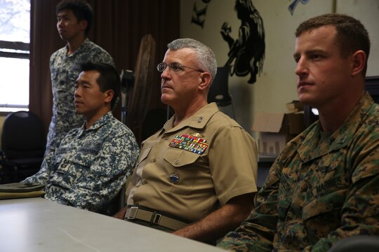 (From left to right:) Singaporean Lt. Col. Francis Goh, the commanding officer for the Underwater Demolition Group with Singapore’s Naval Dive Unit; Maj. Gen. James S. Hartsell, the mobilization assistant to the U.S. Pacific Command commander; and Capt. Richard Laszok, the company commander for Bravo Company, 3rd Reconnaissance Battalion, watch as members of the UDG give a presentation over Singapore’s dive tactics Feb. 27, 2015 in one of the School of Infantry-West classrooms in building 223 aboard Marine Corps Base Hawaii. (U.S. Marine Corps photo by Lance Cpl. Harley Thomas/released)