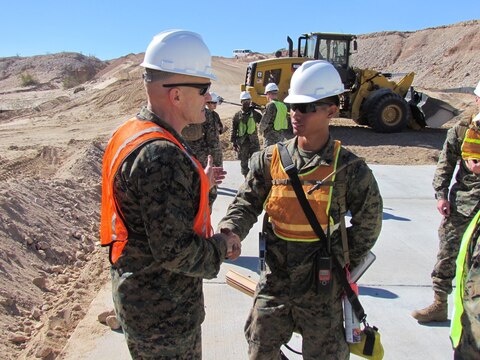 Major Gen. Vincent Coglianese, left, 1st Marine Logistics Group Commanding General, shakes hands with a combat engineer Marine with 7th Engineer Support Battalion, 1st MLG, during a visit to El Centro, California, Feb. 26, 2015.  Marines arrived during January, providing engineering support to construct an all-weather road in El Centro, California, along the United States-Mexico border to increase U.S. border patrol mobility and support the interdiction of transnational threats. (U.S. Marine Corps photo by 1st Lt. Thomas Gray/ Released)