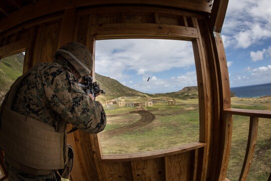 A Marine with Scout Sniper Platoon, Weapons Company, 2nd Battalion, 3rd Marine Regiment, shoots an M4 service rifle down range and Battery Bluff aboard Marine Corps Base Hawaii, March 5, 2015. Opening day to the new urban terrain, unknown-distance range equipped with 20 static and 13 moving targets. The new range is comprised of three wooden structures that are three stories tall. The range creates a realistic urban terrain-training environment. (U.S. Marine Corps photo by Lance Cpl. Brittney Vella/Released)