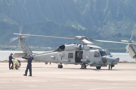 Sailors from Helicopter Maritime Strike Squadron 37 guide incoming and outgoing crews flying MH-60R Seahawk helicopters into Marine Corps Air Station Kaneohe Bay, March 10, 2015. The Navy squadron conducted two three-hour helicopter searches for missing hiker Daylenn Pua around Haiku Stairs, March 4. (U.S. Marine Corps photo by Christine Cabalo/Released)