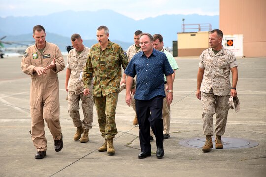 Royal Australian Air Force Wing Group Commander Rohan Gaskill, center left, and Australian Consul-General Jeffrey Robinson, walk along Marine Corps Air Station Kaneohe Bay hangars during a tour with Marines attached to Marine Heavy Helicopter Squadron 463 March 17, 2015 aboard Marine Corps Base Hawaii. The tour came a week before the unit's official inspection of five CH-53E Super Stallions slated to be sent to Marine Rotational Force-Darwin, Australia later this year. It takes 1,500 man-hours per aircraft to make the helicopters inspection-ready for the deployment.