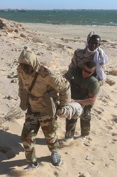 Mauritanian Fusilier Marins carry a U.S. Marine while practicing tactical combat casualty care in Nouadhibou, Mauritania, March 19, 2015. Approximately 20 U.S. Marines, Sailors and Coast Guardsmen with Special-Purpose Marine Air-Ground Task Force Crisis Response-Africa trained with the Mauritanians, practicing infantry skills, small boat operations, combat marksmanship, and close-quarters combat techniques. (Courtesy photo)