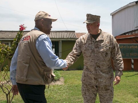 Lt. Gen. John E. Wissler shakes hands with Alfonso Lenhardt May 5 at Tribhuvan international airport before they depart to village Bhirkuna Deurali, Nepal. Wissler, Lenhardt and other members of the United States Agency of International Development will distribute supplies including tarps, sleeping systems and water purification solutions. The Nepalese Government requested the U.S. Government’s help after the earthquake on April 25. USAID is a U.S. Government agency that gives civilian foreign aid in time of natural disasters. Wissler is the commanding general of III Marine Expeditionary Force. Lenhardt is the USAID acting administrator.