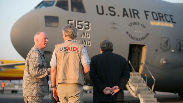 Lt. Col. Kenneth Hoffman, Bill Berger, the DART team leader and Peter W. Bodde witness the 36th Contingency Response Group arrive bringing in a 28-man team May 5 at Tribhuvan International Airport. The team consisted of pilots, mechanics, medical personnel and other trained airmen in order to assist Nepal after the earthquake. The Nepalese Government requested the U.S. Government’s help after the earthquake. USAID is a U.S. Government agency that gives civilian foreign aid in time of natural disasters. Hoffman is the Joint liaison officer. Berger is the Disaster Assistance Response Team leader. Bodde is the United States Ambassador for Nepal. (U.S. Marine Corps photo by Cpl. Isaac Ibarra/Released)