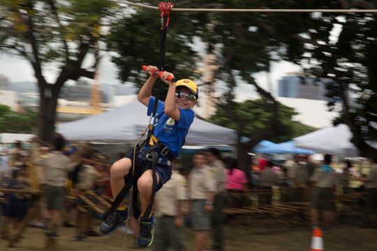 Jordan Perry, a Cub Scout, slides down a 40-foot-long zip-line during the Makahiki event May 9, 2015. Perry could only go down the line once he completed crossing the monkey bridge and rope bridge. (U.S. Marine Corps photo by Cpl. Khalil Ross/Released)