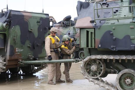 Cpl. Darin Bean, left, and Lance Cpl. Nicholas Cascone, both amphibious assault vehicle crewmen with AAV Platoon, Company B, Ground Combat Element Integrated Task Force, attach a tow-bar to an AAV during a pilot test May 9, 2015, at Red Beach training area, aboard Camp Pendleton, California. The GCEITF AAV Platoon is executing the final phase of their Marine Corps Operational Test and Evaluation Activity assessment by conducting beach and water-borne tasks. From October 2014 to July 2015, the GCEITF will conduct individual and collective level skills training in designated ground combat arms occupational specialties in order to facilitate the standards-based assessment of the physical performance of Marines in a simulated operating environment performing specific ground combat arms tasks. (U.S. Marine Corps photo By Gunnery Sgt. Matt Epright/Released)