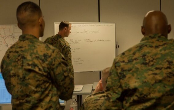 Maj. Ryan Shea, a future operations officer with 2nd Marine Logistics Group, writes strategic planning methods on a white board during the 2nd MLG Staff Exercise at Camp Lejeune, N.C., Nov. 4, 2015. The exercise, a command control scenario, was conducted with efforts to refine the group's planning and execution process that would act as a standard for subordinate commands.