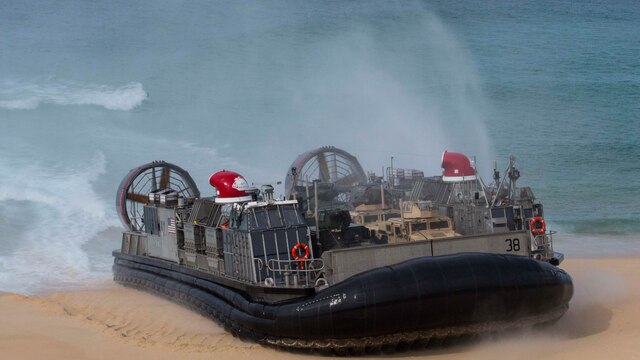 A landing craft air-cushion, or LCAC, transporting U.S. Marines, with the 26th Marine Expeditionary Unit and Portuguese Marines from the USS Arlington, Kearsarge Amphibious Ready Group lands at Pinheiro Da Cruz, Praia Da Raposa beach in Portugal, to participate in a combined amphibious assault exercise, Oct. 20, 2015, during Trident Juncture 15. Trident Juncture is a NATO-led exercise designed to certify NATO response forces and develop interoperability among participating NATO and partner nations. 