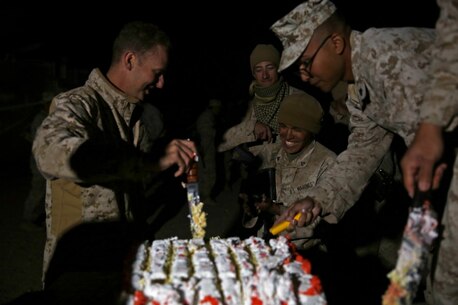 Captain Brian Jaquith, company commander of Co. A, 3rd Assault Amphibian Battalion, 1st Marine Division, cuts and presents cake in celebrate of the Marine Corps’ 240th birthday aboard Yuma Proving Grounds, Ariz., Nov. 10, 2015. The Marines and Sailors celebrated the birthday as a culminating event to the 18-day field operation.