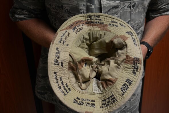 Master Sgt. Curtis Stark, 7th Expeditionary Air Combat Control Squadron superintendent, holds one of his hats inside the Wing Operations Center at at Al Udeid Air Base, Qatar Nov. 15. Stark uses hats like the one pictured here to keep track of his many deployments. He has deployed 17 times in support of contingency operations and has accumulated more than 4,000 combat flying hours. After nearly 30 years of service he plans to retire from the Air Force in March 2016. (U.S. Air Force photo by Tech. Sgt. James Hodgman/Released)