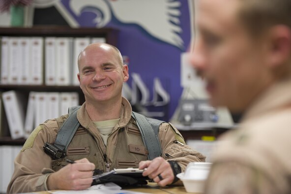 Col. Henry Rogers, 455th Expeditionary Operations Group commander, takes notes during a mission brief before a sortie with the 421st Expeditionary Fighter Squadron at Bagram Airfield, Afghanistan, Nov. 27, 2015. Rogers reached the 3,000-flying hour milestone and 1,000 combat-hour milestone while serving on his eighth combat deployment flying F-16s. (U.S. Air Force photo by Tech. Sgt. Robert Cloys/Released)
