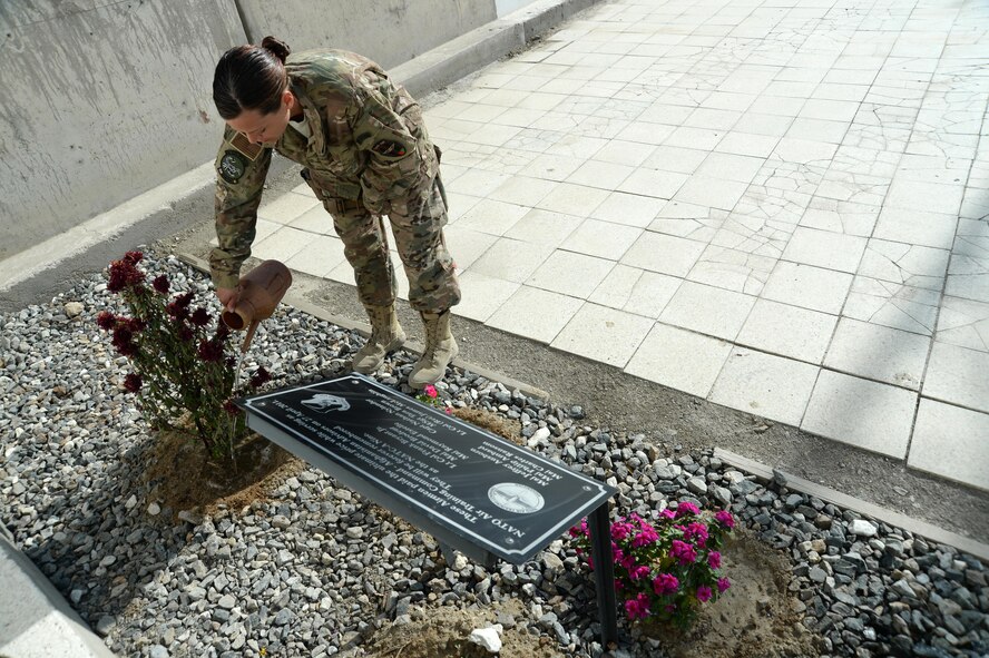 U.S. Air Force Tech. Sgt. Valarie, Train, Advise, Assist Command – Air (TAAC-Air), waters the flowers around the NATO Air Training Command – Afghanistan (NATC-A) Nine Memorial Forward Operating Base Oqab, Afghanistan, Sept. 22, 2015. The 438th Air Expeditionary Advisor Group with funds and donations by the Enlisted Coalition Council built the NATC-A Nine Memorial in April 2013. (U.S. Air Force photo by Staff Sgt. Sandra Welch/released)
