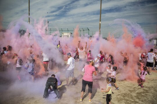 Station residents throw packets of colored powder up in the air during the finale of the Color Me Awareness Run at Penny Lake Field at Marine Corps Air Station Iwakuni, Japan, Oct. 3, 2015. Throughout the run, volunteers were stationed with buckets of colored powder that they threw at participants as they ran by: red representing substance abuse, purple representing domestic violence and pink representing breast cancer awareness.
