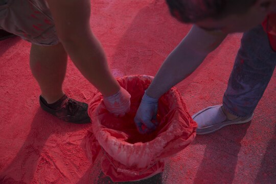 Volunteers grab colored powder to throw at station residents participating in the Color Me Awareness Run at Penny Lake Field at Marine Corps Air Station Iwakuni, Japan, Oct. 3, 2015. This run, coordinated by Behavior Health and Health Promotions, is made to raise the awareness of substance abuse, domestic violence and breast cancer.