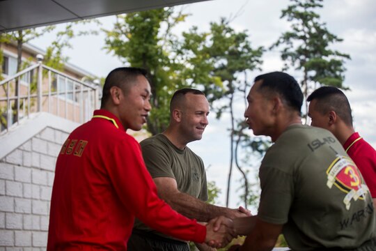 U.S. Marine Lt. Col. Brian P. Coyne, center left, and Republic of Korea Lt. Col. Yoo Hogeun, left, award Capt. Jim C. Wang for winning the soccer competition event at sports day during Korean Marine Exchange Program 15-12 at Chung Ryong, Republic of Korea, Sept. 12, 2015. The Marines participated in a number of events to include a weighted pack run, soccer, basketball and tug of war. KMEP 15-12 is a continuous bilateral training exercise that enhances the ROK and U.S. alliance, promotes stability on the Korean Peninsula and strengthens ROK and U.S. military capabilities and interoperability. Coyne, from Long Island, New York, is the commanding officer of 2nd Battalion, 3rd Marine Division, currently attached to 4th Marine Regiment, III Marine Expeditionary Force through the Unit Deployment Program. Hogeun, from Kangwondo, ROK, is the commanding officer of 11th Battalion, 1st Regiment, 2nd Marine Division. Wang, from Fayetteville, North Carolina, is the company commander for Headquarters and Service Company, 2nd Battalion, 3rd Marine Division, currently attached to 4th Marine Regiment, III Marine Expeditionary Force through the Unit Deployment Program. 