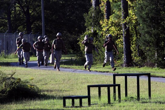 Marines jog with ammo cans and water jugs during a Super Squad Competition hosted by Marine Wing Communications Squadron 28 at Marine Corps Air Station Cherry Point, N.C., Oct. 7, 2015. With a total of seven stations to complete, the Marines powered through physical fatigue, 200 pull-ups divided amongst each individual squad member and memory-challenging exercises. Their ability to work as a team and function under stressful scenarios enables them to provide outstanding support to the Marine Air-Ground Task Force. MWCS-28 provides expeditionary communications for the Aviation Combat Element of the II Marine Expeditionary Force. (U.S. Marine Corps photo by Lance Cpl. Jason Jimenez/Released)