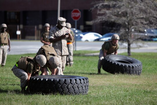 Marines flip tires during a Super Squad Competition hosted by Marine Wing Communications Squadron 28 at Marine Corps Air Station Cherry Point, N.C., Oct. 7, 2015. With a total of seven stations to complete, the Marines powered through physical fatigue, 200 pull-ups divided amongst each individual squad member and memory-challenging exercises. Their ability to work as a team and function under stressful scenarios enables them to provide outstanding support to the Marine Air-Ground Task Force. MWCS-28 provides expeditionary communications for the Aviation Combat Element of the II Marine Expeditionary Force. (U.S. Marine Corps photo by Lance Cpl. Jason Jimenez/Released)