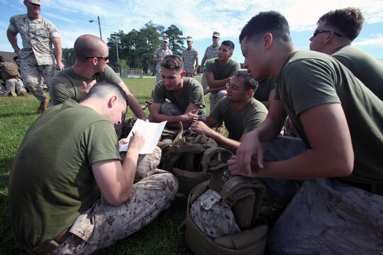 A squad of Marines takes a written exam during a Super Squad Competition hosted by Marine Wing Communications Squadron 28 at Marine Corps Air Station Cherry Point, N.C., Oct. 7, 2015. With a total of seven stations to complete, the Marines powered through physical fatigue, 200 pull-ups divided amongst each individual squad member and memory-challenging exercises. Their ability to work as a team and function under stressful scenarios enables them to provide outstanding support to the Marine Air-Ground Task Force. MWCS-28 provides expeditionary communications for the Aviation Combat Element of the II Marine Expeditionary Force. (U.S. Marine Corps photo by Lance Cpl. Jason Jimenez/Released)
