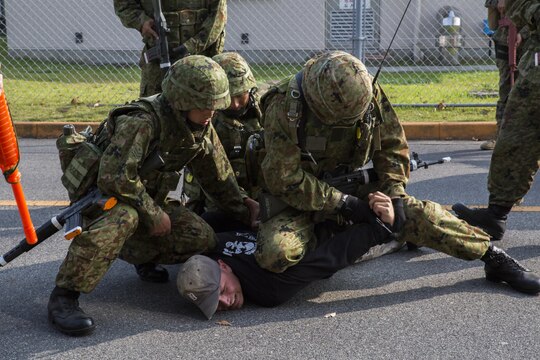 Japan Ground Self-Defense Force soldiers take down a kidnapper as part of a simulated situation during Exercise Guard and Protect at Marine Corps Air Station Iwakuni, Japan, Oct. 20-23, 2015. Guard and Protect is a joint security force operation to promote readiness in case the station has to make a defense posture. Marines and JGSDF soldiers carried out scenarios such as riot control, armed intruder response and vehicle searches.
