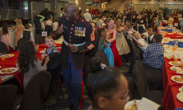 Sgt. Maj. Darnell Richardson, Marine Aviation Logistics Squadron 12 sergeant major, leads kids around in a conga line during the Mini-Marine Corps Ball in the Club Iwakuni ballroom at Marine Corps Air Station Iwakuni, Japan, Oct. 23, 2015. Children dressed up, danced, ate and experienced a Marine Corps tradition during the event. Approximately 345 kids showed up to this years event.