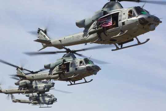 Two UH-1Y Hueys, one AH-1W Super Cobra and one AH-1Z Viper with Marine Light Helicopter Attack Training Squadron (HMLAT) 303 hover several hundred yards away from their target during an aerial demonstration aboard Marine Corps Base Camp Pendleton, Calif., Oct. 24. During the demonstration, Marines on the ground communicated with helicopters to perform a multi-phase, live-fire event. (U.S. Marine Corps photo by Sgt. Lillian Stephens/Released)