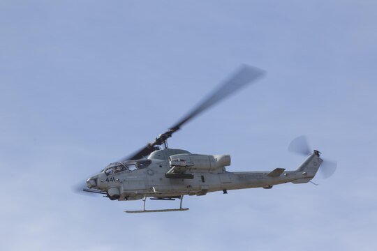 An AH-1W Super Cobra flies over crowds during an aerial demonstration aboard Marine Corps Base Camp Pendleton, Calif., Oct. 24. Marines on the ground communicated with helicopters to perform a multi-phase, live-fire demonstration for the HMLAT-303 Family Day event. (U.S. Marine Corps photo by Sgt. Lillian Stephens/Released)