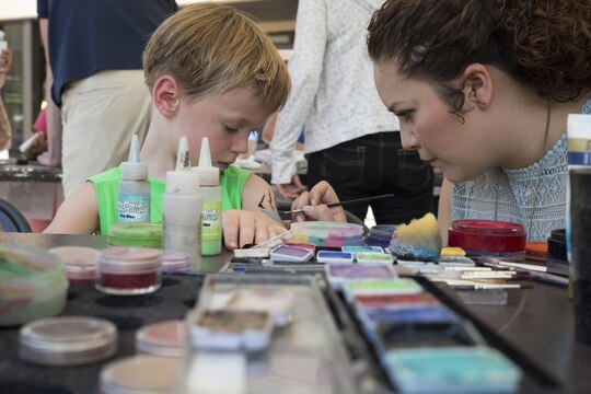Ben Fletcher, an event participant, gets his arm painted at Child Safety Day Event aboard Marine Corps Air Station Iwakuni, Japan, Aug. 27, 2015. The event taught kids a variety of safety tips from how to properly hold a baby and the correct way to wear a back pack, to bicycle safety and household hazards. Face painting, paper crafts and spin the wheel were just a few activities incorporated in the safety event to entertain the participants. (U.S. Marine Corps photo by Lance Cpl. Nicole Zurbrugg/Released)