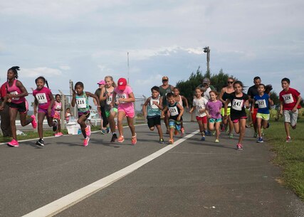 Marines and families with 3rd Combat Assault Battalion, 3rd Marine Division, III Marine Expeditionary Force race during the Kid’s Fun Run, at Torii Station Beach, Okinawa, Japan, Aug. 15, 2015. The run was designed to help build unit morale among Marines and families of the battalion. (U.S. Marine Corps photo by Lance Cpl. Natalie A. Dillon/Released)