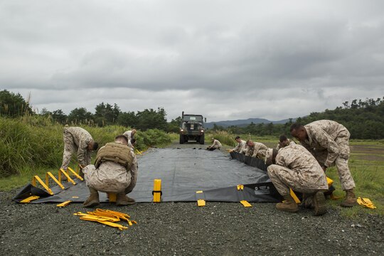 Marines with Marine Wing Support Squadron 171, stationed aboard Marine Corps Air Station Iwakuni, Japan, lay down a berm to catch any fuel that could possibly leak out of the MK970 semi-trailer refueler at Sekiyama Training Area, Japan, Sept. 8, 2015, in support of Exercise Forest Light 16-1. MWSS-171 is supporting Marine Heavy Helicopter Squadron 462 and 1st Battalion 2nd Marines during this exercise using their communications, motor transport and refueling capabilities.