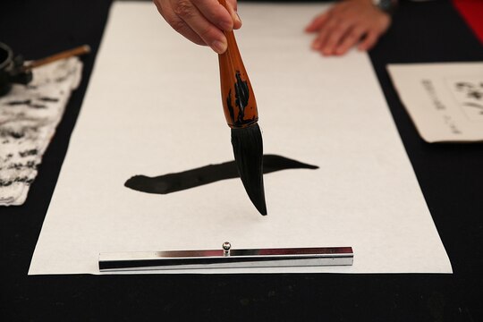 A resident of Marine Corps Air Station Iwakuni, Japan, participate in a calligraphy contest during a cultural adaption program trip to the annual Japanese Calligraphy Brush Festival in Kumano, Hiroshima Prefecture, Sept. 23, 2015. Held in the capital of brushes, this city is home to approximately 1,500 “fude-shi,” brush-making craftsman and twenty master artisans of fude. This ancient tradition of Kumano-fude making dates back to the 18th century and became a way of life for villagers seeking income. 