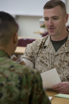 Staff Sgt. Robert Durham, operations manager with American Forces Network Iwakuni provides feedback to a Japan Ground Self-Defense Force member during an English seminar at Marine Corps Air Station Iwakuni, Japan, Sept. 14, 2015. Durham showed the translators hand gestures and mannerisms Americans typically used during conversation to help break down possible language barriers between Americans and the Japanese. Seminars like this boost comradery between Americans and Japanese by increasing the ability to communicate with each other.