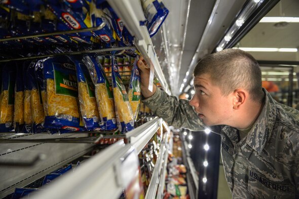 An Airman volunteers to help restock Commissary shelves on Sheppard Air Force Base, Texas, Sept. 27, 2015. This Airman, along with nearly 150 others, helped rescue nearly $200,000 worth of perishable items from a lighting strike that shut down the commissary power. (U.S. Air Force photo/Tech. Sgt. Mike Meares)