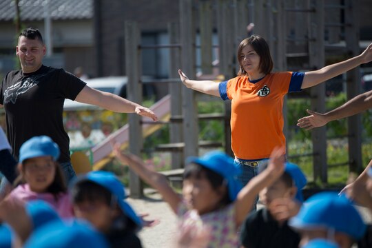 Cpl. Tiffany Ackerman, an air freight clerk with Headquarters and Headquarters Squadron, follows along with preschoolers to a dance routine at Kawashimo Preschool, Iwakuni, Yamaguchi Prefecture, Japan, Sept. 29, 2015. Service members from Marine Corps Air Station Iwakuni volunteered to come out to the preschool to show they are a part of the community and bond with them as well.