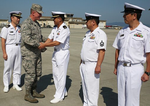 U.S. Air Force Lt. Gen. John L. Dolan shakes hands with Japan Maritime Self-Defense Force Warrant Officer Fumio Ootaki, first, JMSDF Chief Petty Officer Yukihiro Kamouchi, second, and JMSDF Chief Petty Officer Noriaki Tazaki, third, with Air Rescue Squadron 71, during a visit to the JMSDF hangar at Marine Corps Air Station Iwakuni, Japan, Sept. 29, 2015. Dolan took time during his visit to the station to reconnect with the Japanese service members who saved his life over two decades ago. While serving as an F-16 instructor pilot, flight examiner, and assistant chief of standards and evaluation at Misawa Air Base, Dolan departed that day for the Coronet West 30 deployment to Tyndall Air Force Base, Fla., when a KC-135 Stratotanker unexpectedly struck him from below during collision avoidance maneuvers.