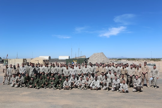 Marines with Marine Unmanned Aerial Vehicle Squadron (VMU) 1 pose together on the runway built by Marine Wing Support Squadron (MWSS) 371 and MWSS-274 at Cannon Air Defense Complex in Yuma, Ariz., March 25. In January, VMU-1 Marines began moving from Marine Corps Air-Ground Combat Center Twentynine Palms, Calif., to the Cannon Air Defense Complex with Marine Aircraft Group (MAG) 13, where they have access to the aerial support they needed to continue operations. (U.S. Marine Corps photo by Lance Cpl. Harley Robinson/Released)