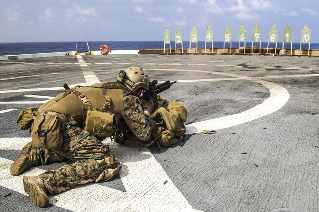 A Marine fires from a kneeling prone position during a deck shoot aboard the USS New Orleans in the Pacific Ocean, April 1, 2016. Marine Corps photo by Sgt. Hector de Jesus