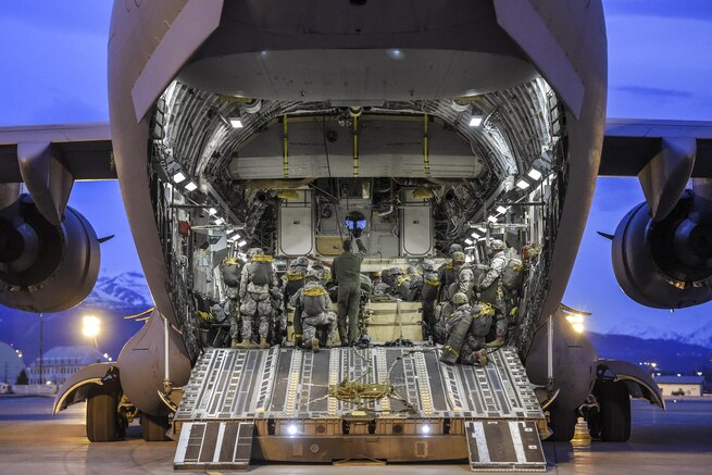 Paratroopers board and position their gear inside an Air Force C-17 Globemaster III aircraft before participating in a night jump at Joint Base Elmendorf-Richardson, Alaska, March 31, 2016. Air Force photo by Alejandro Pena
