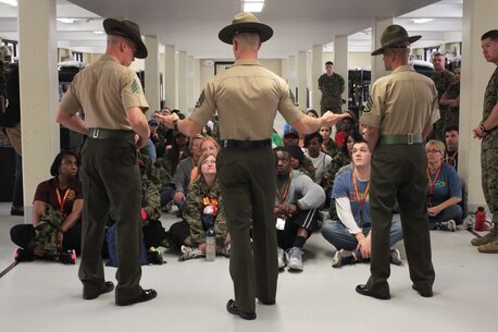 Drill Instructors Sgt Christopher Wade, Staff Sgt. Edward P. Underwood, and Staff Sgt. William Aguilar Castillo give educators a taste of what recruits go through when they first meet their Drill Instructors during receiving April 13, 2016, at Echo Company aboard Marine Corps Recruit Depot Parris Island, S.C. The teachers, coaches, and principals of Recruiting Stations Jacksonville and Montgomery participate in a three-day workshop designed to inform educators about military service and life in the Marine Corps. (Official Marine Corps photo by Cpl. Diamond N. Peden