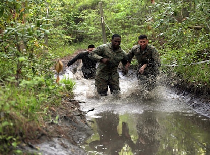 Marines with Combat Logistics Regiment 2 splash their way through one of the many mud puddles during an endurance course at Camp Lejeune, N.C., April 22, 2016. The unit pushed through the grueling 3.4 mile course to improve their ability to work as a team and to build camaraderie.