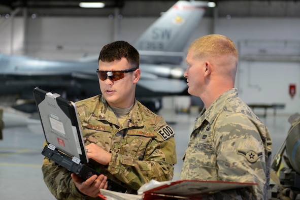 U.S. Air Force Senior Airman Christopher Brown (left,) 20th Civil Engineer Squadron explosive ordnance disposal journeyman, reviews F-16CM Fighting Falcon explosive mitigation technical orders with Airman Tyler Kochlany (right), 20th CES explosive ordnance disposal apprentice, during explosive mitigation training at the 20th Maintenance Group weapon standardization and evaluation hangar, April 22, 2016, at Shaw Air Force Base, S.C. Airmen from various career fields utilize TOs as guidelines when performing their respective jobs. TOs help reduce the chance of error when assembling or disassembling parts on many pieces of equipment. (U.S. Air Force photo Airman 1st Class Christopher Maldonado)