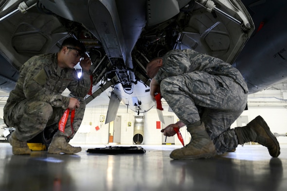 U.S. Air Force Senior Airman Christopher Brown (left,) 20th Civil Engineer Squadron explosive ordnance disposal journeyman, and Airman Tyler Kochlany (right,) 20th CES explosive ordnance disposal apprentice, apply marker pins to an F-16CM Fighting Falcon during explosive mitigation training at the 20th Maintenance Group weapon standardization and evaluation hangar, April 22, 2016, at Shaw Air Force Base, S.C. The pins help identify areas the Airmen have previously checked for munition jams or flare misfires. (U.S. Air Force photo by Airman 1st Class Christopher Maldonado)
