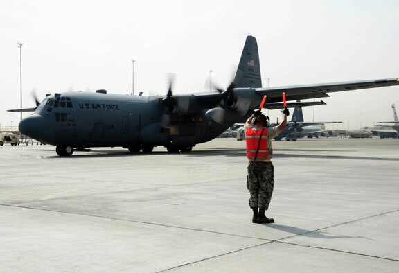 Senior Airman Steven Engels, 379th Expeditionary Aircraft Maintenance Squadron crew chief, marshals a C-130 Hercules on the flight line June 28, 2016, at Al Udeid Air Base, Qatar. Airmen from the 379th EAMXS are responsible for ensuring the aircraft are maintained to exact standards to support Operation Inherent Resolve and Operations Freedom’s Sentinel. (U.S. Air Force photo/Senior Airman Janelle Patiño/Released)