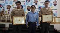 Lance Cpl. Luis Rosas, left, and Cpl. Ian Burnham, right, are presented a letter of appreciation by Eikatsu Sakihara, the Chief of the Urasoe City Police Department at the Urasoe City Police Department, Okinawa, Japan, Aug. 23, 2016. Rosas and Burnham were awarded for their efforts in assisting an Okinawa resident from a burning vehicle, and eliminating hazards at the scene of a car crash on April 16. Rosas is a Wilmington, Calif. native, and an engineer equipment mechanic with Combat Logistics Regiment-35, 3rd Maintenance Bn., 3rd Marine Logistics Group, III Marine Expeditionary Force. Burnham is a Spokane, Washington native, and electrical engineer equipment systems technician with CLR-35, 3rd Maintenance Bn., 3rd MLG, III MEF.
