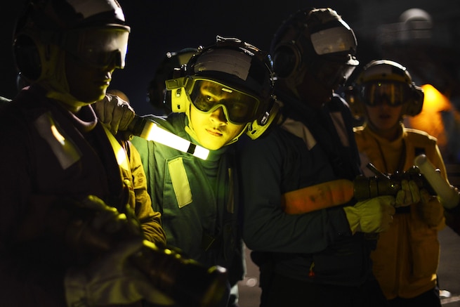 Navy Airman Alan Chhay participates in a nighttime firefighting drill on the flight deck of the aircraft carrier USS Nimitz at Naval Base Kitsap-Bremerton, Wash., Aug. 23, 2016. The Nimitz is undergoing extended planned incremental maintenance. Navy photo by Seaman Recruit Cody M. Deccio