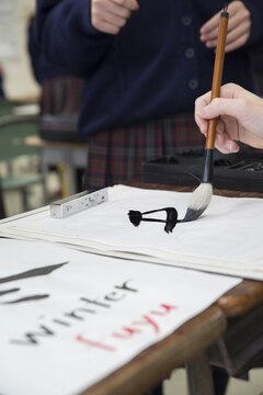 A student from Matthew C. Perry Junior High School writes Japanese calligraphy during a cultural exchange event at Takamori Midori Junior High School in Kuga, Japan, Feb. 2, 2016. Japanese students loaned their brushes and ink to M.C. Perry students and showed them the techniques used in calligraphy. M.C. Perry students were introduced to the traditional style of Japanese junior high school with Japanese calligraphy, science and a math class.