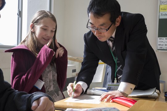 Yutaka Tsuda,a mathematics teacher at Takamori Midori Junior High School in Kuga, Japan, explains a math problem to Ashley Atkins, a seventh-grader from Matthew C. Perry Junior High School, during a cultural exchange at Midori Junior High Feb. 2, 2016. M.C. Perry students integrated into various classes at Midori Junior High to experience the traditional Japanese classroom environment. Cultural events are a great opportunity for students to learn about a new culture and use their language skills.