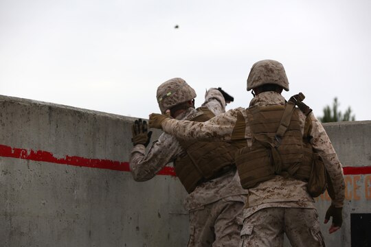 Cpl. Justin Heslep, left, throws An M69 Practice Grenade as Cpl. Nathan Queen supervises during a grenade and MK19 Grenade Launcher range at Marine Corps Base Camp Lejeune, N.C., Oct. 28, 2015. More than 70 Marines with 2nd Low Altitude Air Defense Battalion took turns handling the MK-19 and handheld grenades during the familiarization range. The range offered Marines the opportunity to build confidence and proficiency skills on some of the crew-served weapons they operate while providing security in a deployed environment. Heslep and Queen are both low altitude aerial defense gunners with the battalion. (U.S. Marine Corps photo by Cpl. N.W. Huertas/Released)