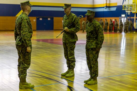 Sgt. Maj. Coleman Kinzer, left, outbound Headquarters and Headquarters Squadron sergeant major, prepares to pass on the sword of office to Sgt. Maj. Darnell Richardson, right, newly appointed H&HS sergeant major, during a relief and appointment ceremony at Marine Corps Air Station Iwakuni, Japan, Feb. 26, 2016. The passing of the sword of office represents the transition of duties and responsibilities from one sergeant major to another. Kinzer addressed the Marines of the squadron, stating that he believes without them, the transformation of the air station wouldn’t be possible.
